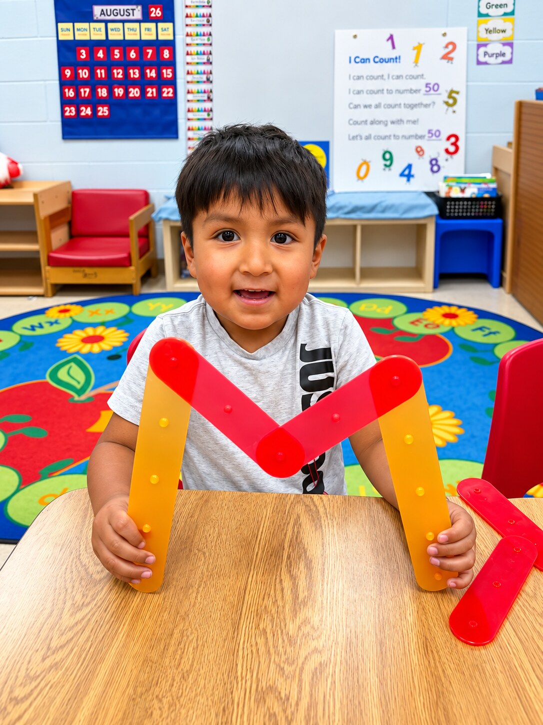 A smiling child builds with large colorful shapes.