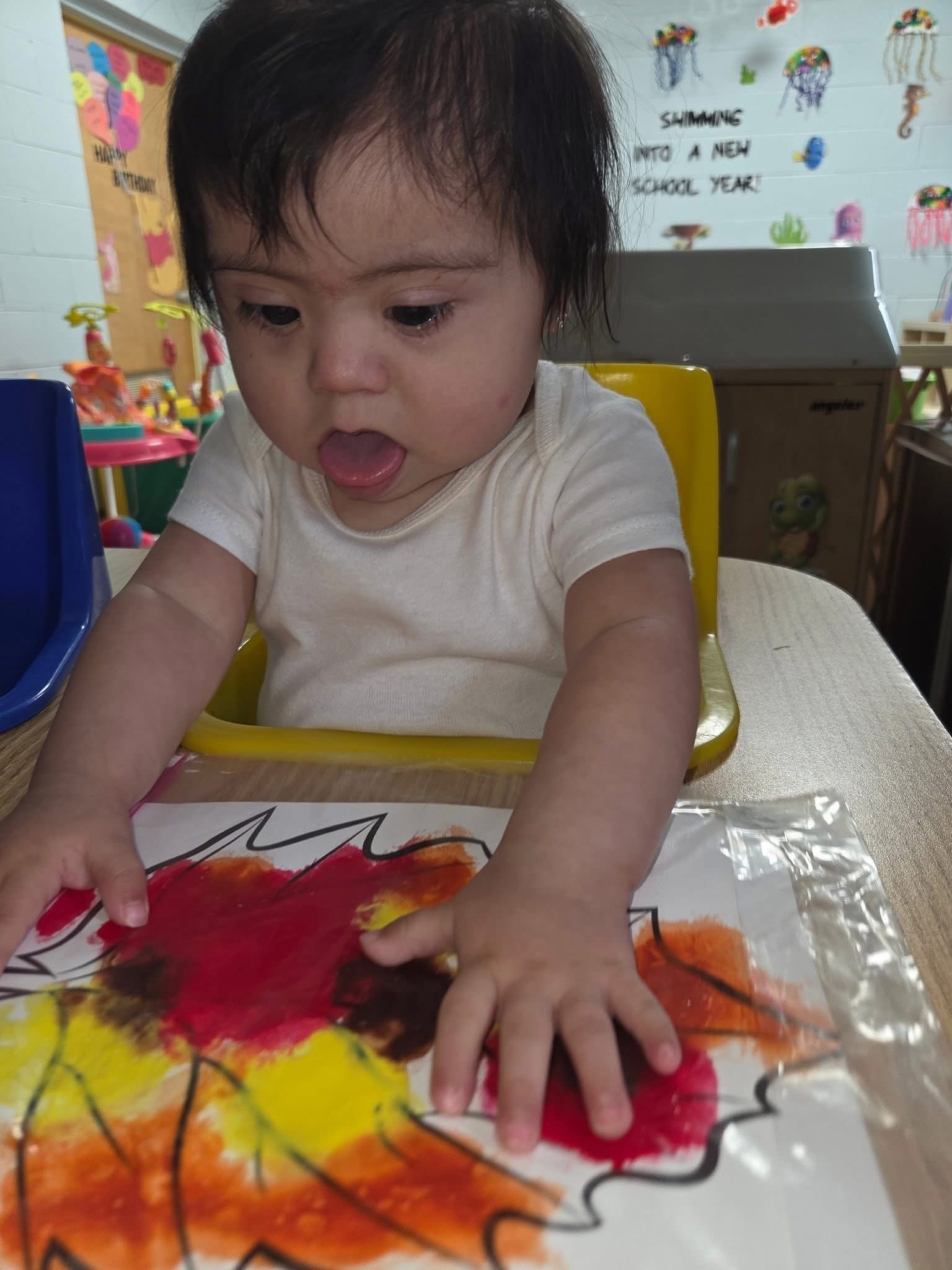 A young child exploring paint through hands-on art