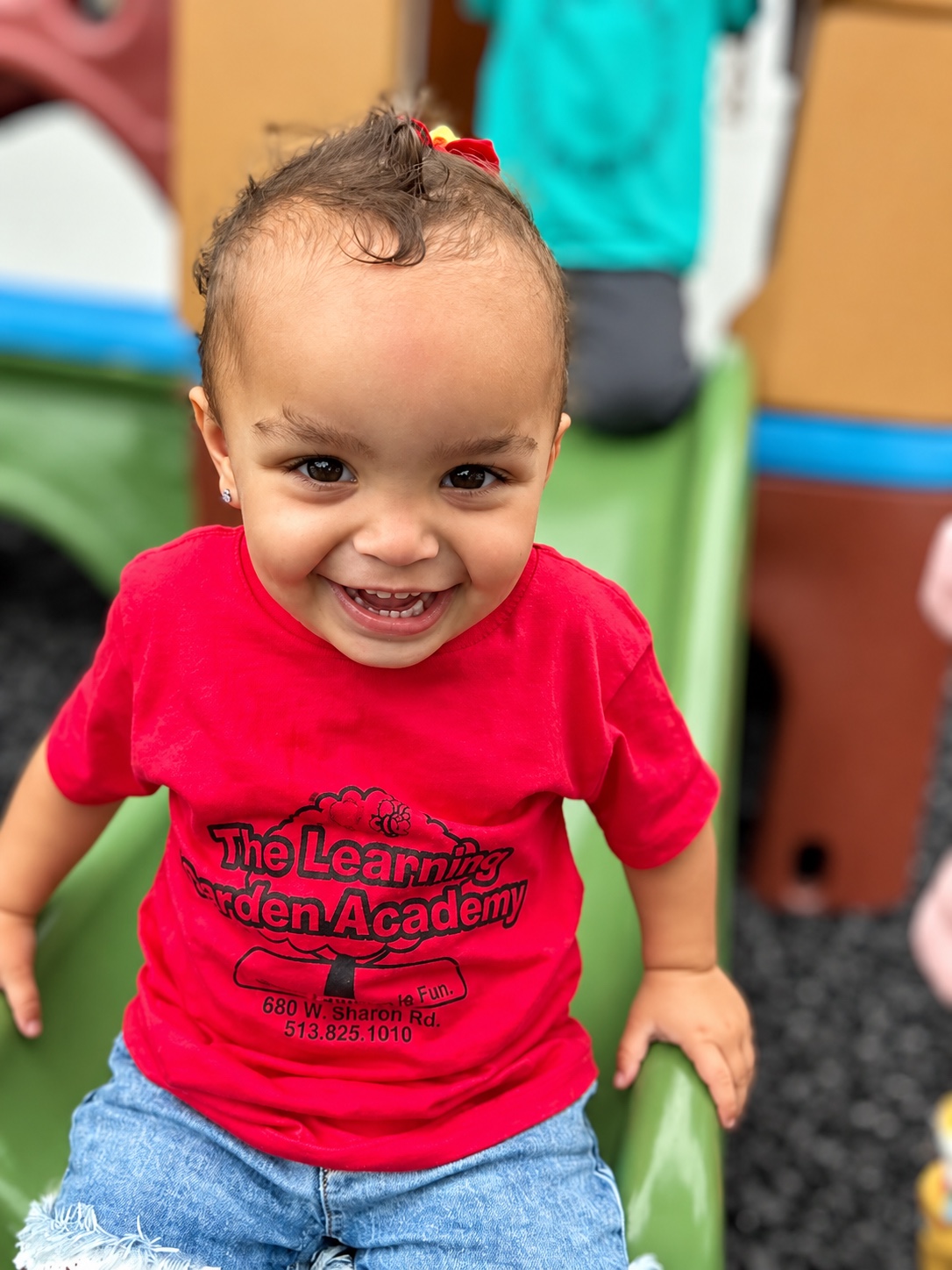 A smiling young learner in the toddler classroom
