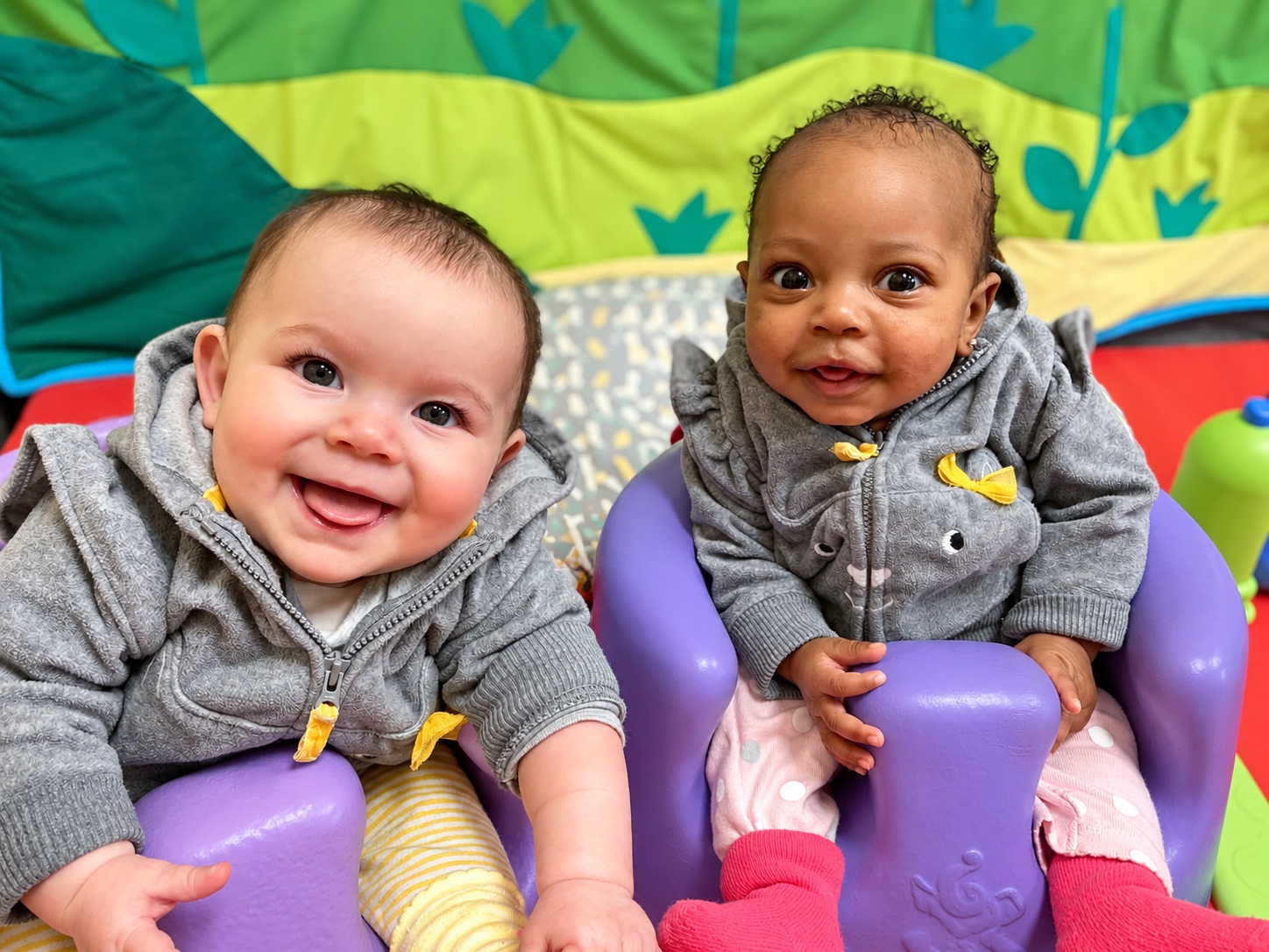 Two smiling infants enjoying time together in the Turtles classroom