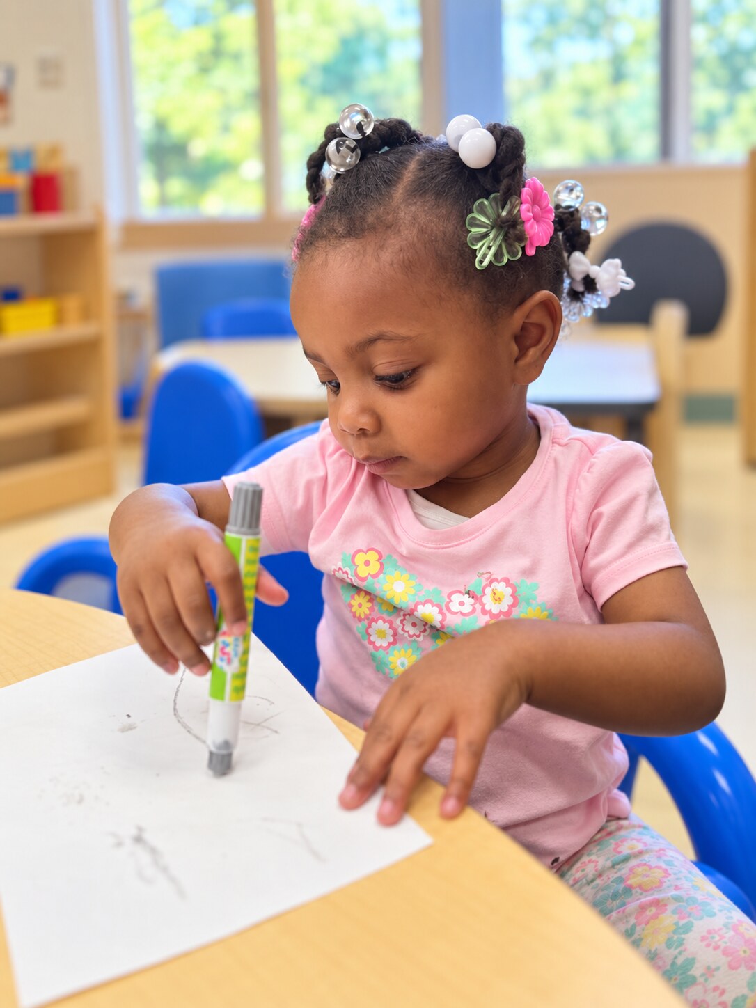 A child uses an eyedropper to explore a small science activity.