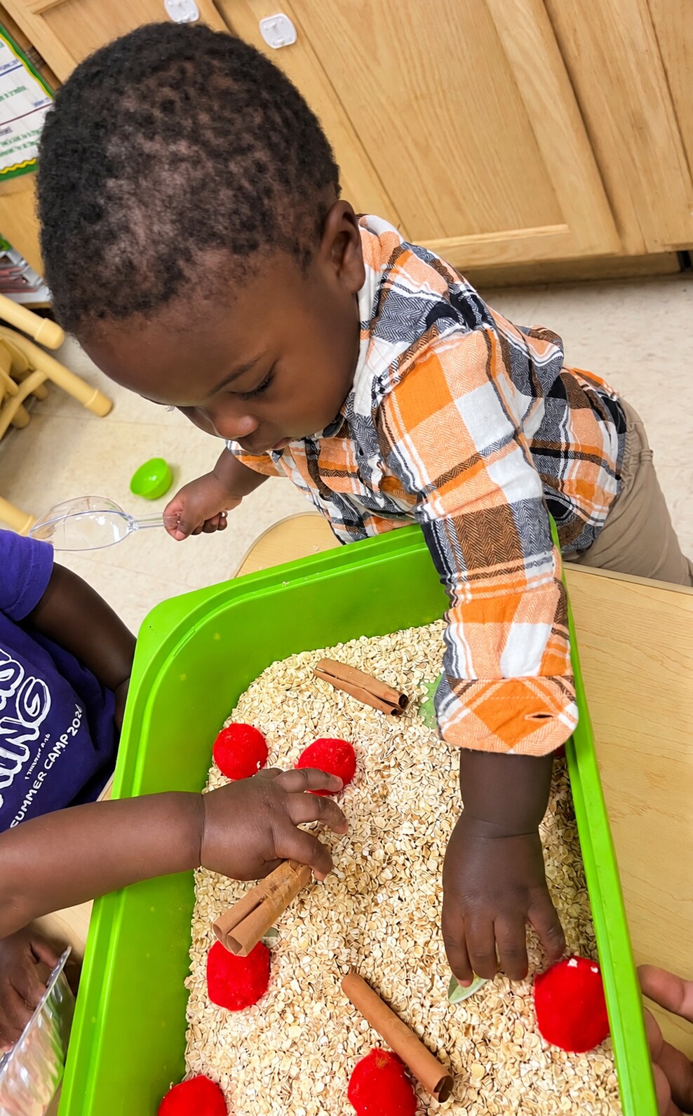 A teacher shares a sensory activity with a young child.