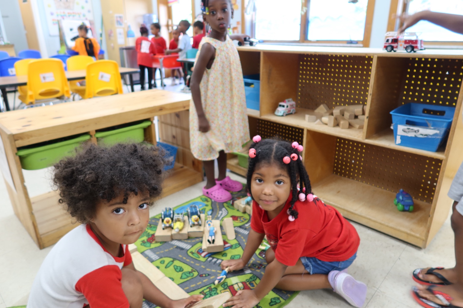 Two children build and play together with large blocks.