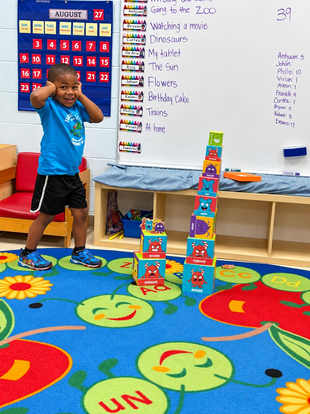 A child shares an idea beside the classroom feelings chart.