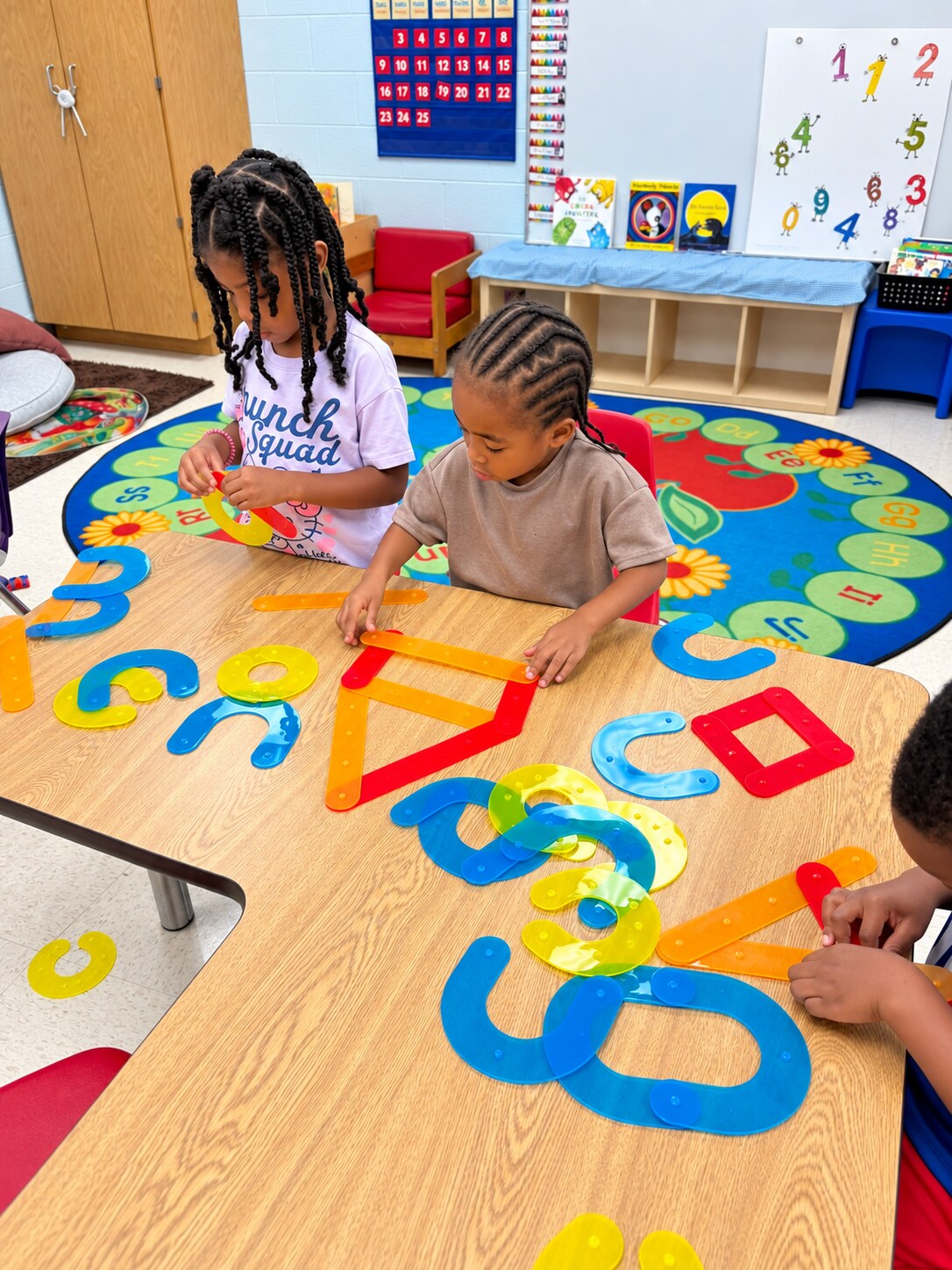 Children explore shape and number materials together.
