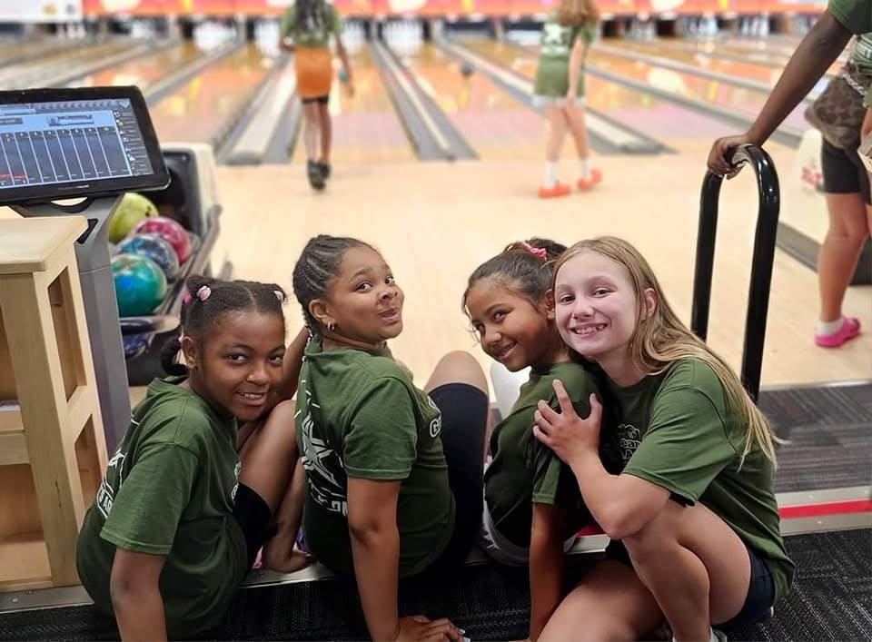 Children enjoy bowling together during a group outing.