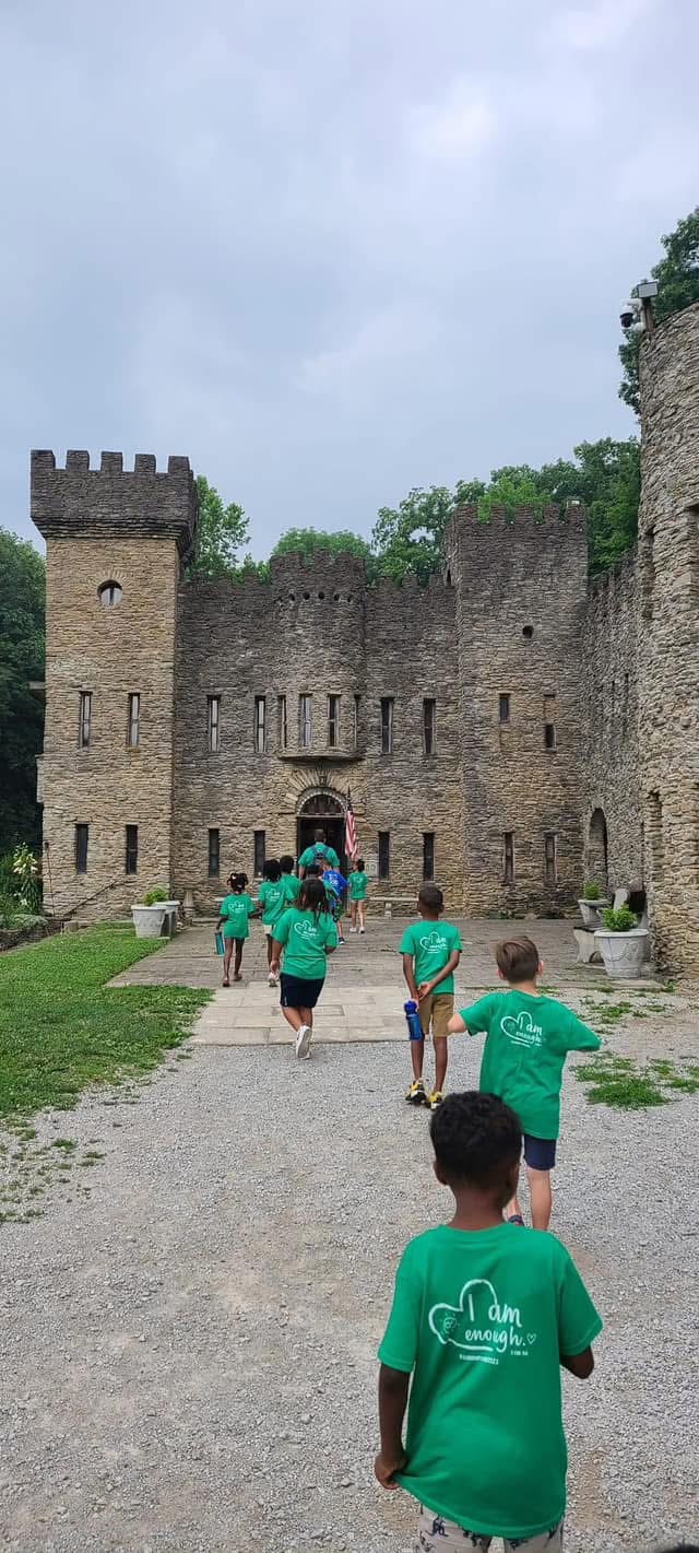 Children explore a stone fort together on an outing.